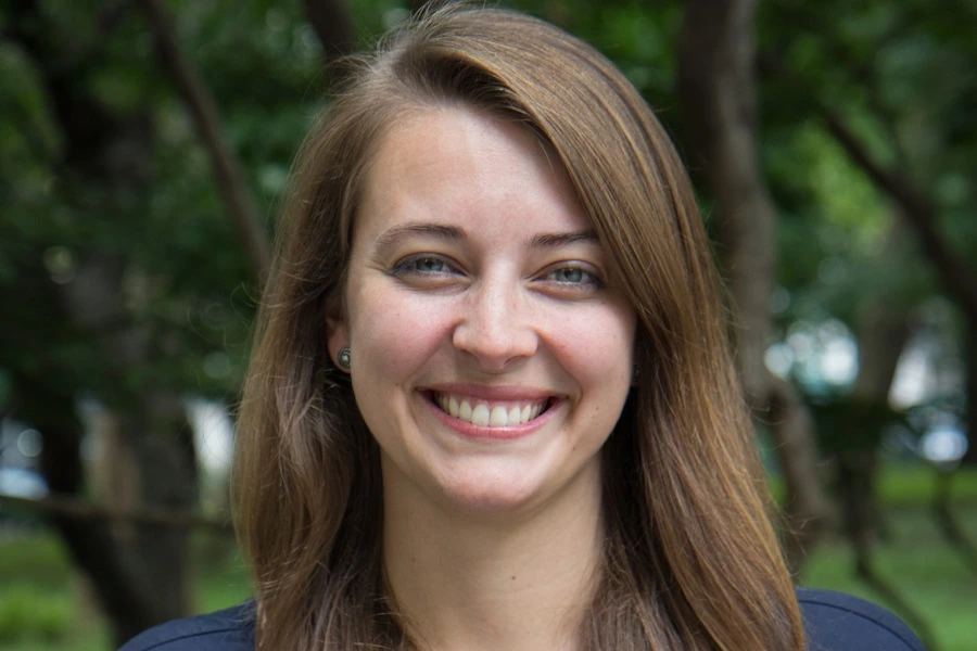 young woman smiling with trees in backdrop